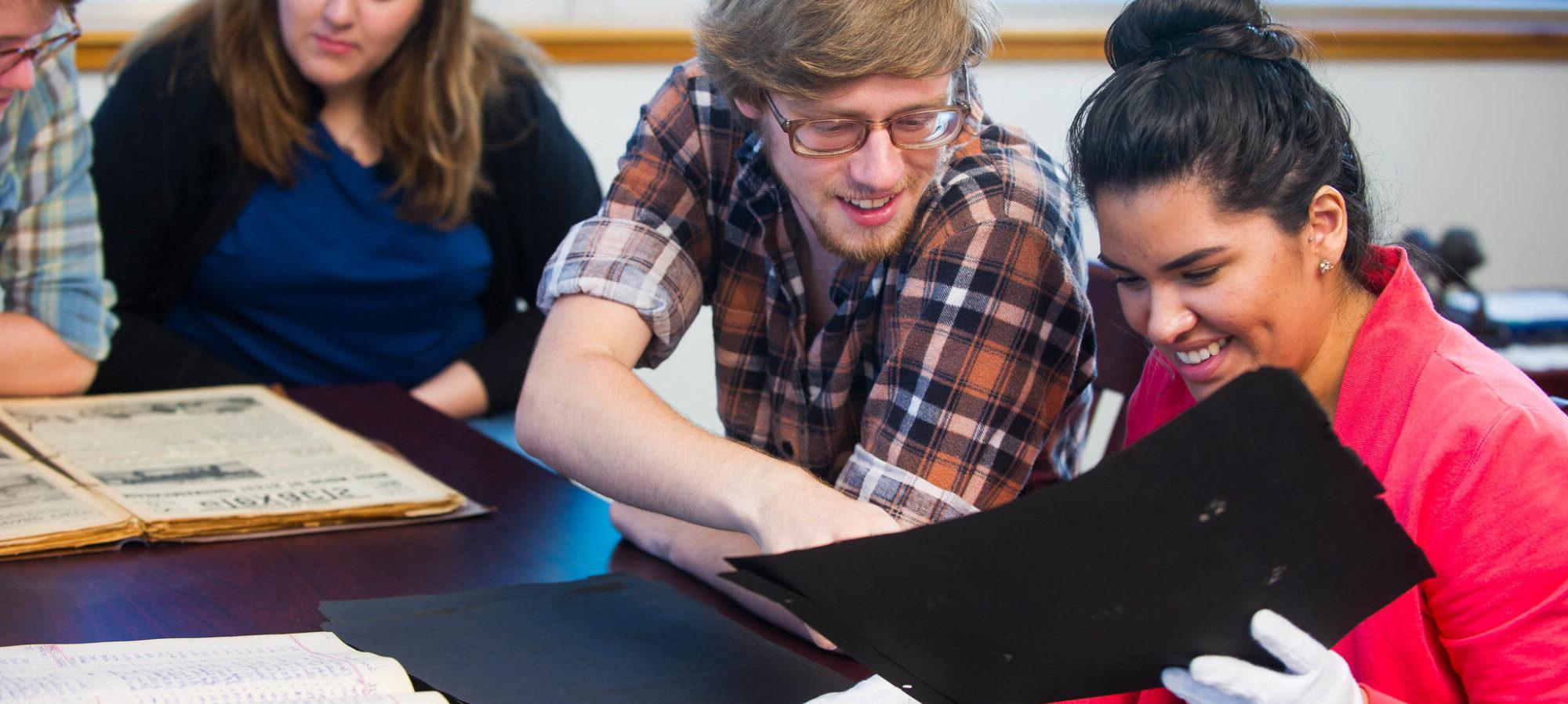 Group of students looking over written artifacts.