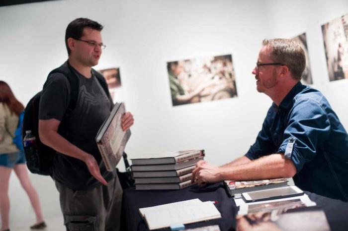 Man signing books at a book signing.