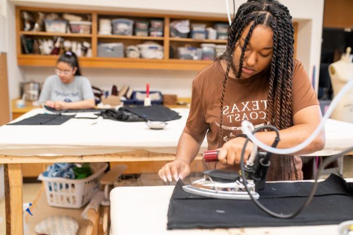 a female student ironing a costume